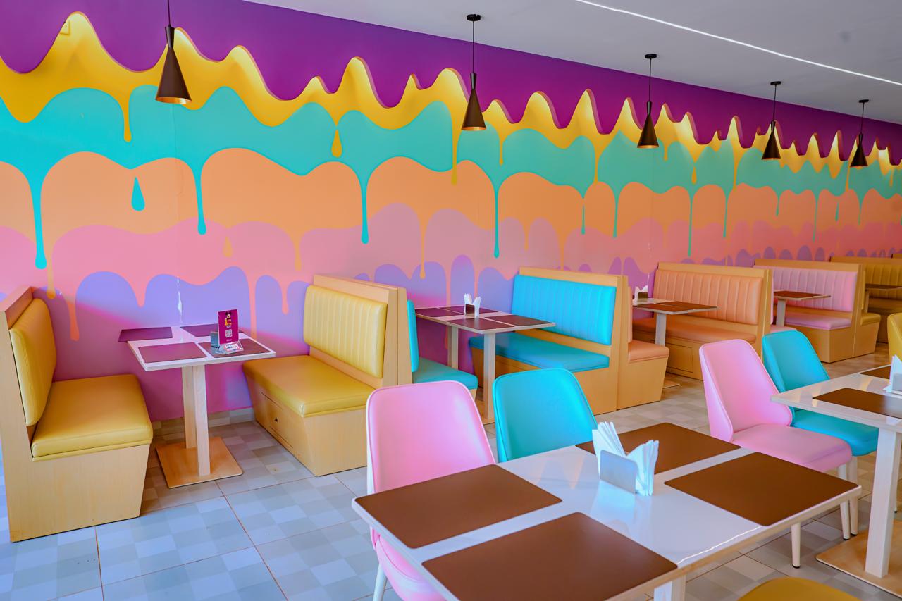 Booths and pastel chairs below the melting ice cream wall
